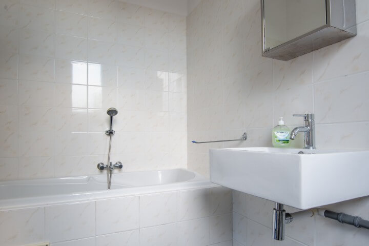 Deze ruime badkamer heeft een ligbad, douche en wasmachine.